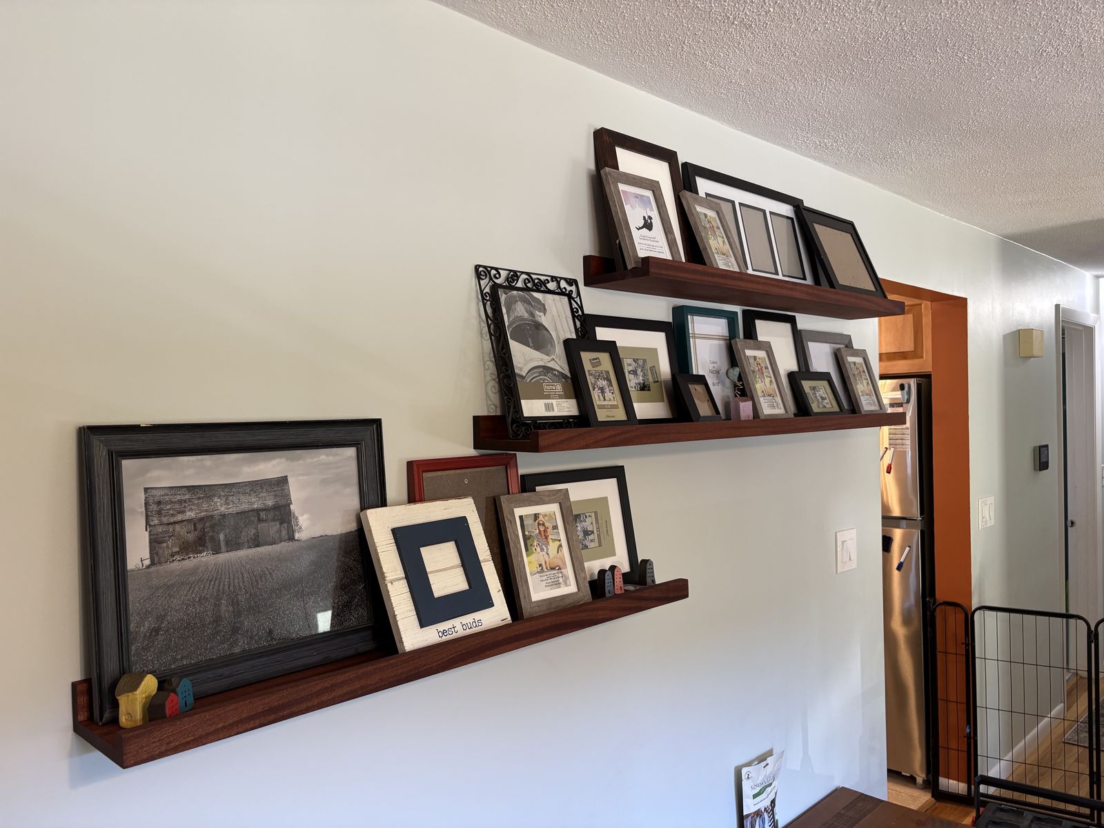 Wood picture-ledge shelves filled with framed photos